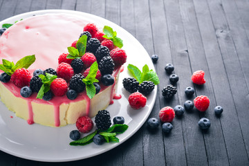 Cake with butter and fresh berries and fruits. Dessert. On a wooden background. Top view. Free space for your text.