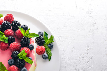 Cake with butter and fresh berries and fruits. Dessert. On a wooden background. Top view. Free space for your text.