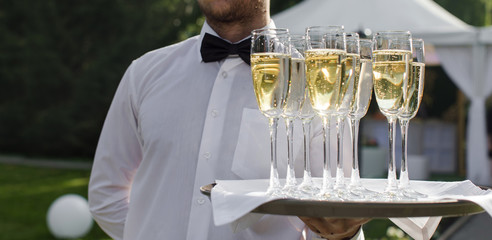 Waiter serving champagne on a tray