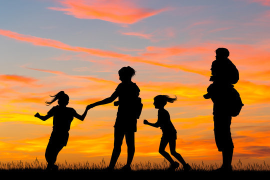 joyful family silhouette at sunset