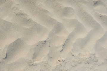A frontal close up of tractor tire tracks on beach sand. Shot from directly above