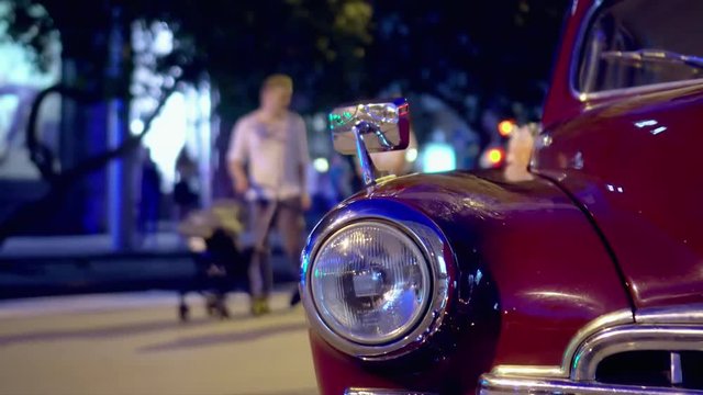 Headlight of the vintage red car close plan. the vintage car costs at an exhibition of the night city