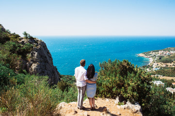 A couple in love travels. Boy and girl at the sea. Travelers. Man and woman have a rest abroad. The relationship between a man and a woman. Honeymoon trip. Newlyweds on their honeymoon. On the edge