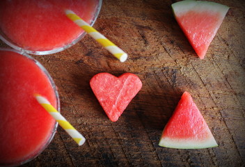 Obraz na płótnie Canvas Healthy watermelon smoothie with of watermelon in heart shape on a wood background