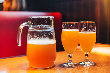 a pitcher and two glasses of beer in cafe