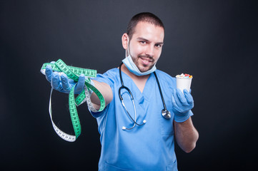 Plastic surgeon wearing scrubs holding measuring tape and pills