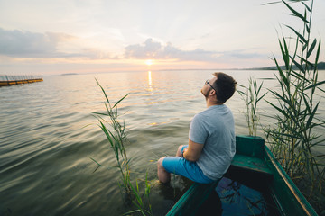 Fototapeta premium man sitting in the old boat thinking