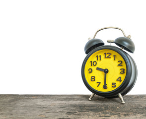 Closeup black and yellow alarm clock for decorate show half past nine or 9:30 a.m. on old brown wood desk isolated on white background with copy space