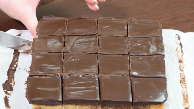 Cutting chocolate cake. Woman's hand cuts cake.