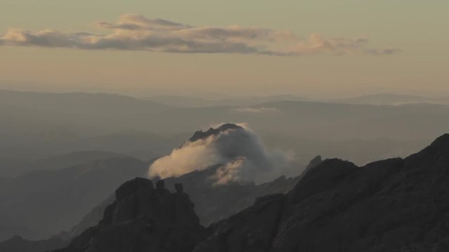 Clouds circeling a mountain in sunset