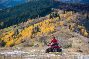 Man is driving off-road vehicle on a mountain road passes to the top of the mountain followed by a beautiful landscape of mountains woodlands with a variety of color of the trees green, yellow, red