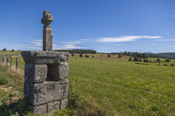 Fototapeta na wymiar Croix en pierre en bord de route sur l'Aubrac