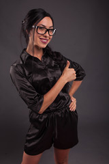Young cheerful woman portrait of a confident businesswoman showing by hands on a black background. Ideal for banners, registration forms, presentation, landings, presenting concept.