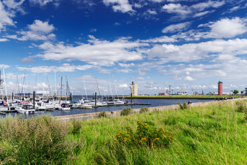 waterfront in Cuxhaven, Germany with lighthouse in background - obrazy, fototapety, plakaty