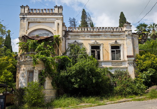 Old beautifull abandoned mansion overgrown by plants and trees. Sukhum, Abkhazia