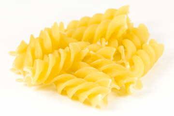 dried raw, uncooked fusilli pasta noodles isolated on white background