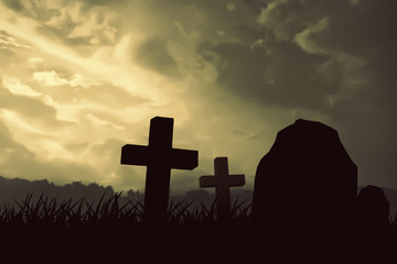 Halloween Concept, The tombstone and crucifix silhouette, with an orange sky illuminated by full moonlight covered with fog.