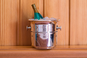 Kitchen timer shaped like champagne bottle and bucket on a wood background