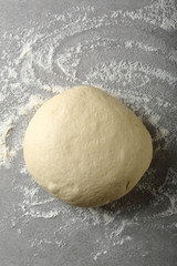 Ball of pizza dough with dusting flour