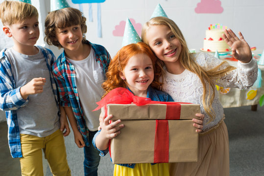 adorable happy kids holding gifts while standing together at birthday party