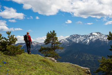 Fototapeta premium Man traveler stands on the edge of the cliff