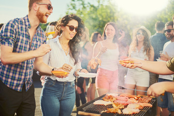 Couple standing and drinking alcohol at barbecue party - obrazy, fototapety, plakaty