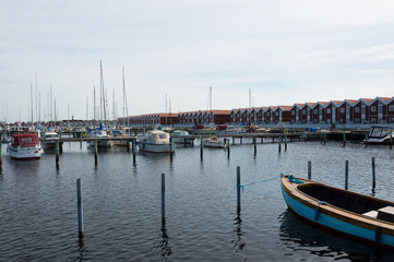 Fototapeta na wymiar Denmark, Northern Jutland, Nibe. The towns marina/harbor with typical red wooden danish buildings and ships.