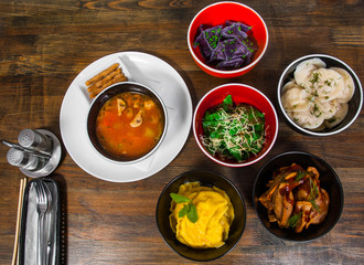 Set of different dumplings and ravioli on a wooden table. top view.