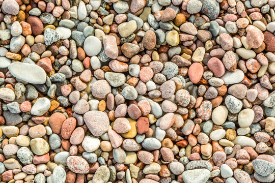 Many round and smoth colorful pebbles seen from above.