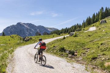 Mountainbiker in Carnic Alps with view to mountain Rosskofel