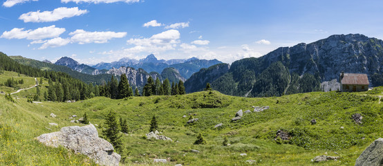 View from Auernig Alm with old huts to Julian Alps