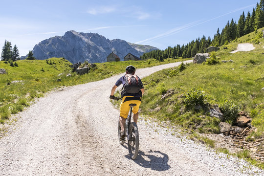 Mountainbiker in Carnic Alps with view to mountain Rosskofel