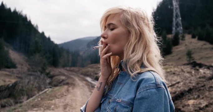 Beautiful woman smoking a cigarette. Hand hield footage. 4k. Red Epic