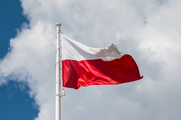 Waving national flag of Poland on a flagpole, national colors of Poland.