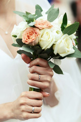 Obraz na płótnie Canvas Bride holds wedding bouquet in her tender hand