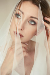 Fototapeta premium Stunning bride with deep blue eyes under the veil