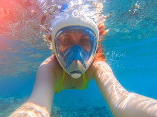 Fototapeta premium Snorkel girl underwater selfie. Snorkeling in full face mask. Summer activity.