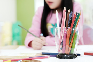 Color pencils on table in kindergarten classroom, education background