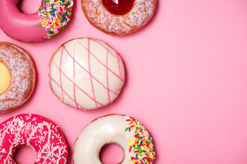 Donuts with icing on pastel pink background. Sweet donuts.