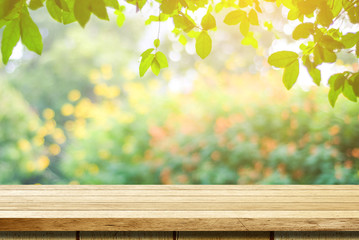 Naklejka na ściany i meble Empty wooden table over blurred tree with bokeh background, for product display montage