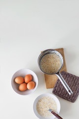Breakfast with oatmeal and eggs. White table