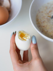 Breakfast with oatmeal and eggs. White table