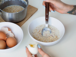 Breakfast with oatmeal and eggs. White table