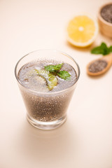 Selective focus of chia seeds drink with water in transparent glass with lemon balm.