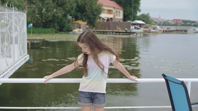 Stylish little model posing at camera on pool background 4K