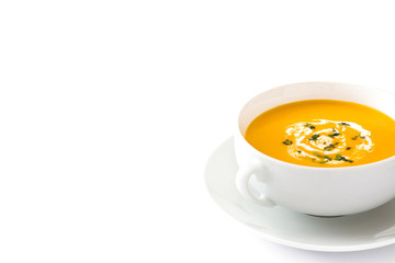 Pumpkin soup in white bowl on wooden table
