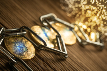 Bitcoin with chain, on wood background