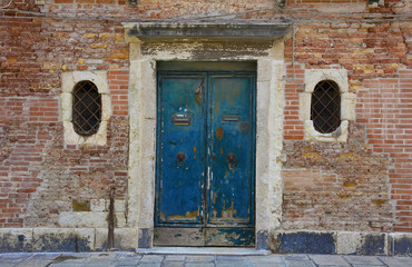 An old wooden door in a derelict building in the Dorsoduro quarter of Venice
