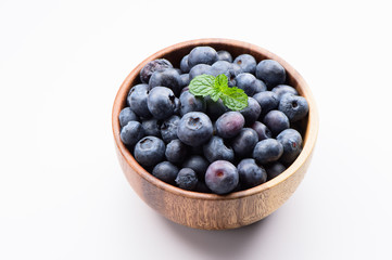 close up blueberry with vanilla mint in a wooden bowl isolated on white background
