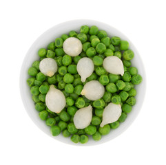 Top view of a small white bowl with cooked pearl onions and green peas.
